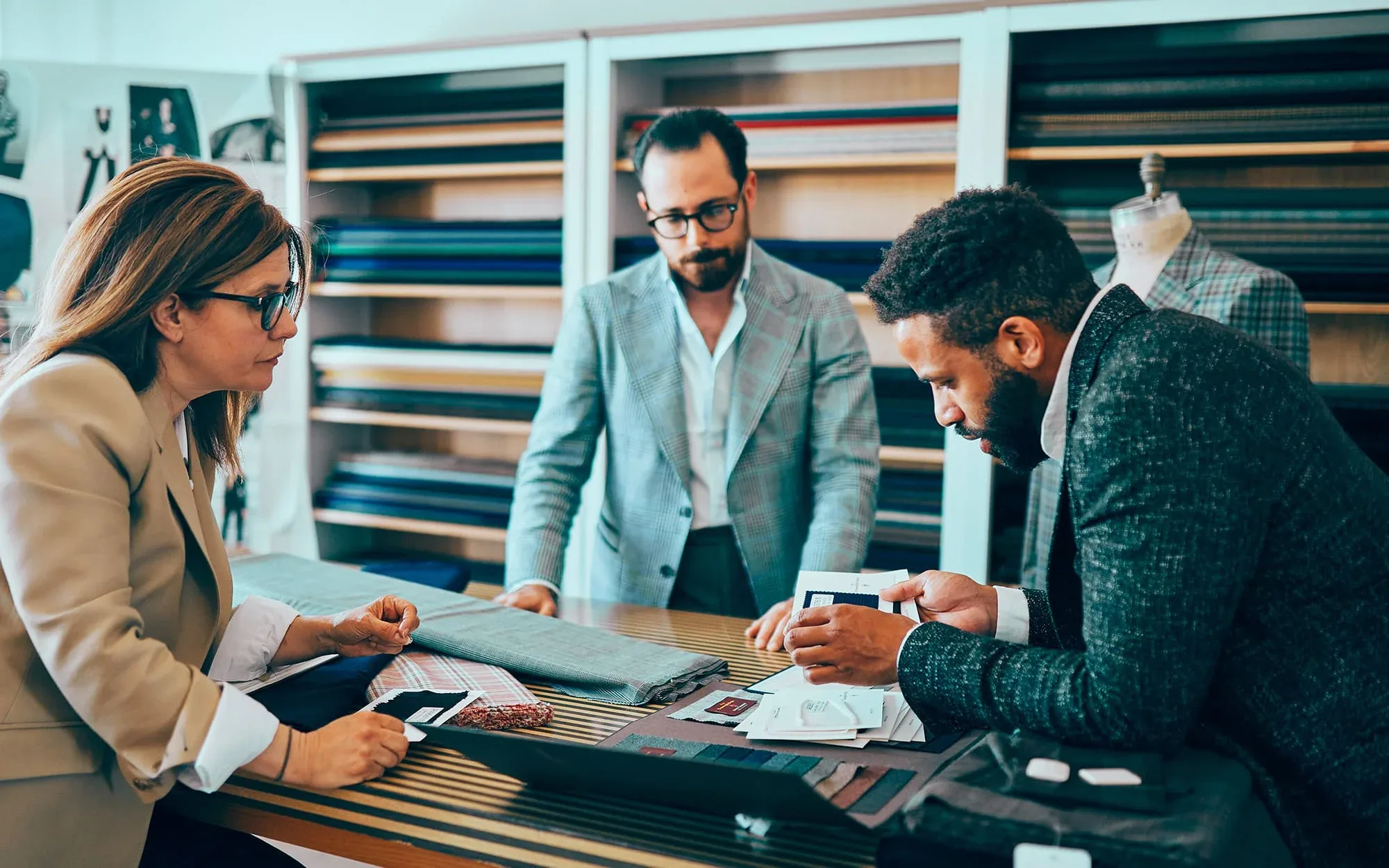 Three people looking at different textures and fabrics around a table